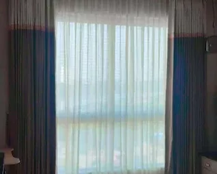 Sheer and main curtains installed by M R Venetians on a bedroom window